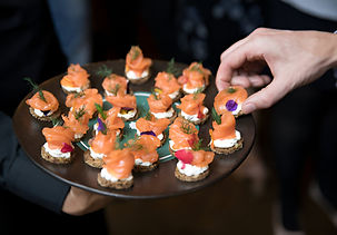 Variety of colorful gourmet canapés and hors d'oeuvres on a slate serving board.
